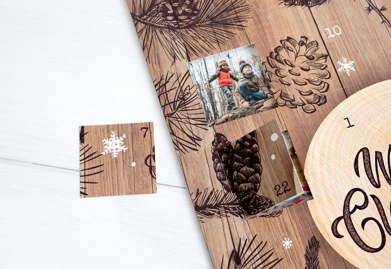 Gepersonaliseerde foto-adventskalender met een houten thema, met dennenappel en sneeuwvlokontwerpen. Twee open vensters onthullen aangepaste foto