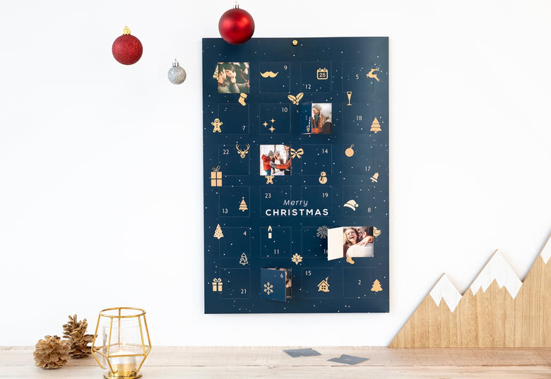 Blauwe foto-adventskalender met aanpasbare fotovensters, gouden feestelijke iconen en de tekst "Merry Christmas" in het wit.