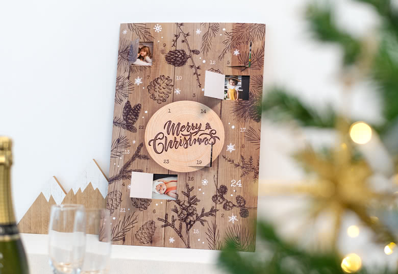 Gepersonaliseerde foto-adventskalender met een rustiek houten ontwerp, dennenappel en takillustraties, en aanpasbare fotovensters.