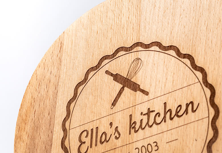Round wooden cutting board with personalised engraving reading "Ella