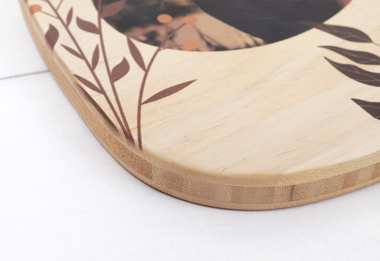 Round wooden cutting board with personalised engraving reading "Ella