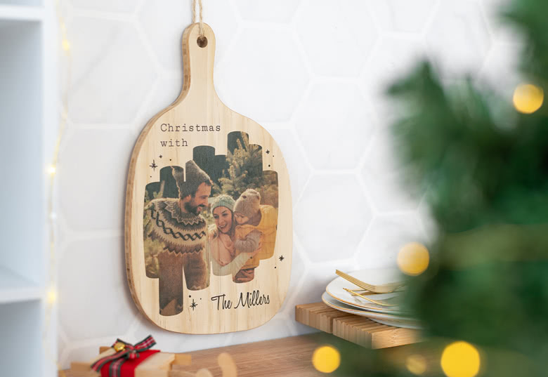 Wooden cutting board with a light brown finish, featuring a personalised photo and the text "Christmas with The Millers".