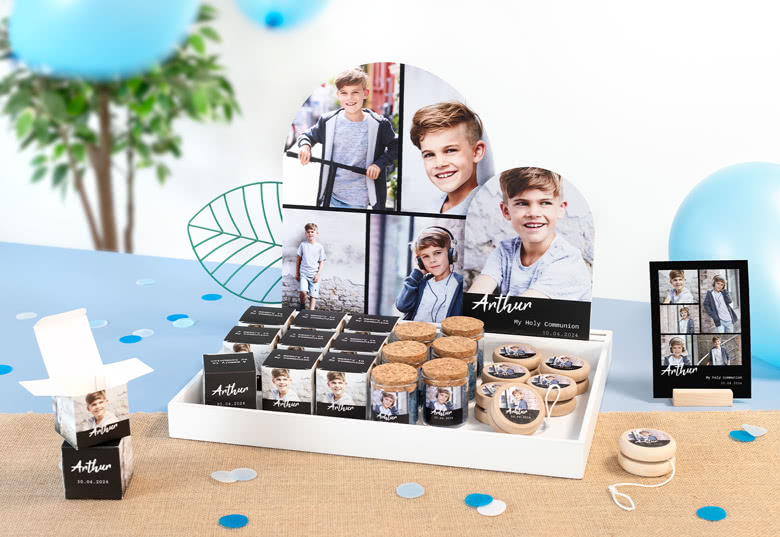 Personalised communion favours display with photos and name "Arthur". Includes small boxes, cork jars, yo-yos and photo cards.