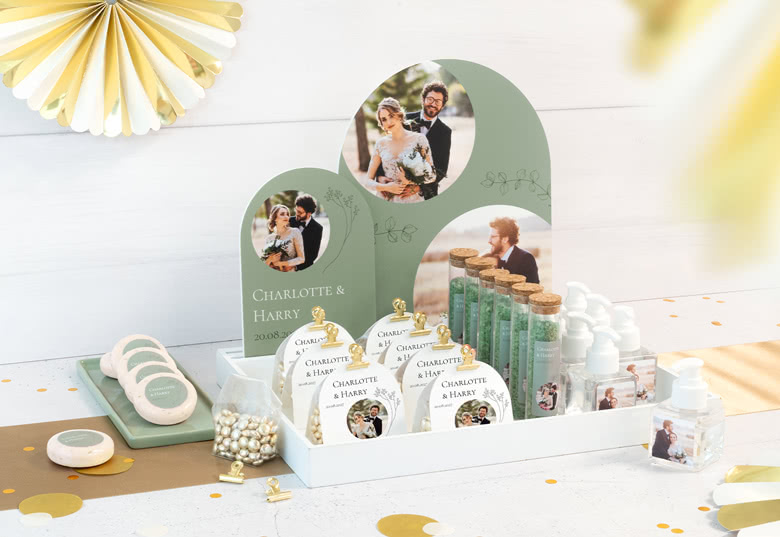 Personalised wedding favour display with photos of a couple, featuring green and gold accents, and labelled with "Charlotte and Harry".