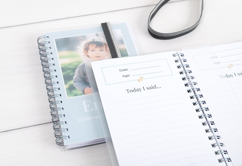 Personalised spiral-bound notebooks with a light blue cover featuring a child