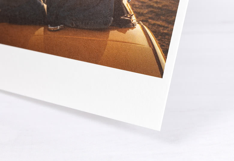Close-up of a personalised photo refill card showing a white border and an image featuring a car roof and legs in blue jeans.