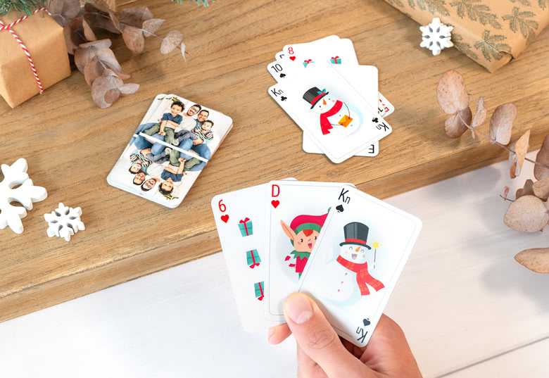 Personliga julkortsspel med festliga motiv som jultomten, en tomtenisse och en julgran, med ett anpassat familjefoto på baksidan.
