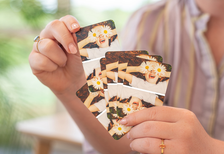 Aangepaste kerst speelkaarten met een foto van een kind met madeliefjes over hun ogen, vastgehouden in iemands hand.