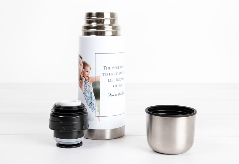 Witte thermos met een personaliseerbare foto van een moeder en kind, met de tekst "From Lang" en een zilveren dop ernaast.